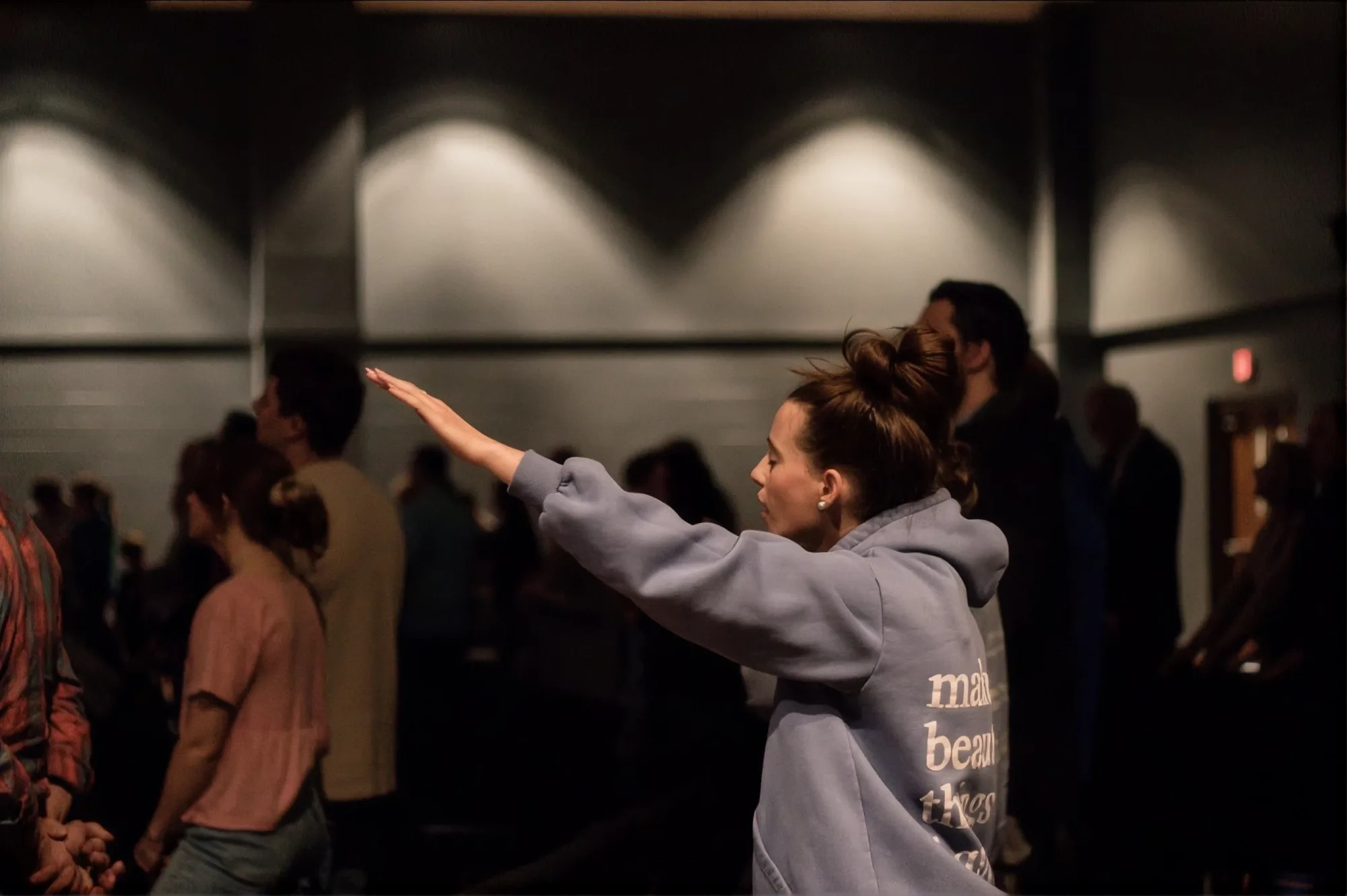 A woman raises her hand in worship during a Celebrate Recovery gathering at Journey Church