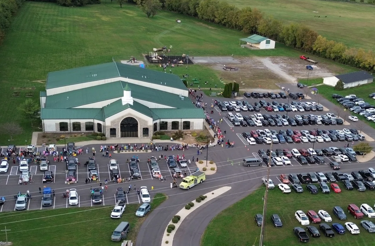 Aerial view of Journey Church's building and full parking lot with families walking in for a service.
