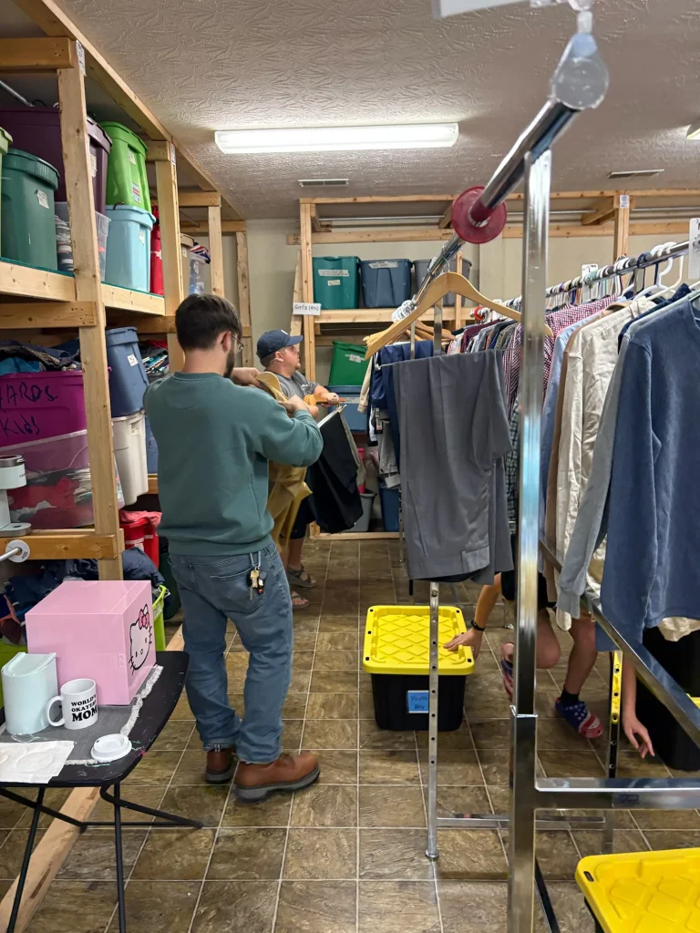 A Journey Provisions volunteer sorts donated clothing on racks in the stockroom.
