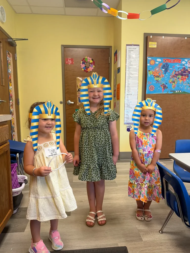 Three Journey Kids students wear handmade pharaoh headdresses during a Bible lesson about Moses and Egypt.
