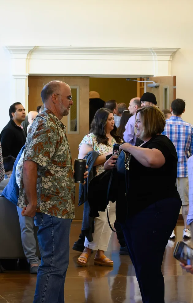 Guests talk with one another in the hallway outside a Journey Church gathering space before a group meets.
