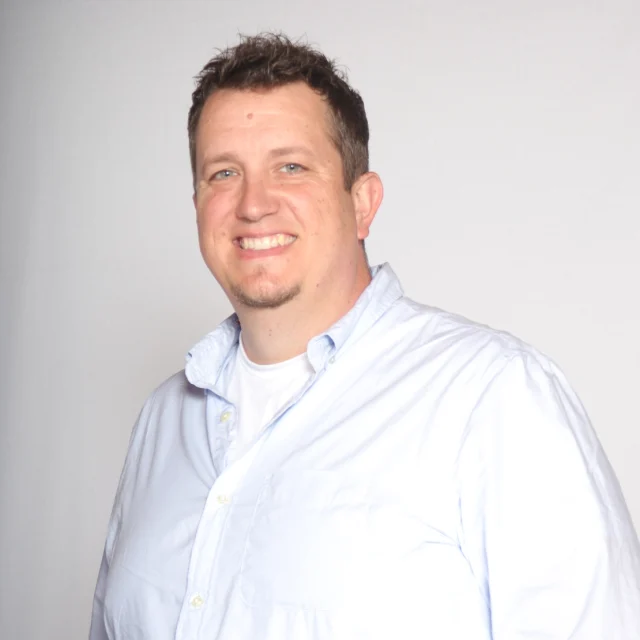 Dan Prout, Worship Pastor at Journey Church, smiling in a light blue button-down shirt.