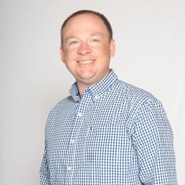 Eric Rice, Executive Pastor at Journey Church, smiling in a blue checkered button-down shirt.