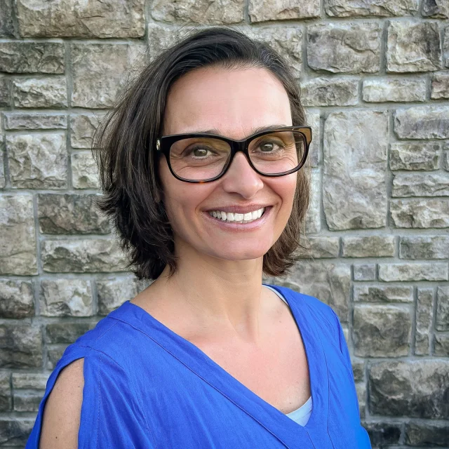 Tabatha Wood, Preschool Teacher at Journey Preschool, smiling in glasses and a blue top.